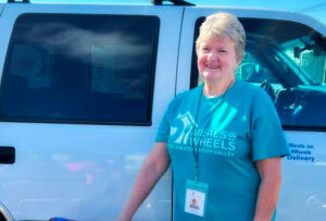 MOWGLV volunteer Bonnie Sipics smiling at her car.